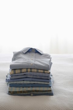 Ironed And Folded Shirts On Bed