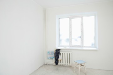 Dirty Clothes On Radiator Under Window Of Apartment