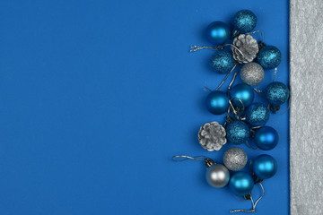 New Year's blue and silver balls and cones on a blue background. Place for an inscription. Card. Christmas. 2020 color. The trend of the year.
