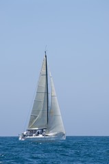 Fototapeta premium Sailboat Racing In The Blue Ocean Against Sky