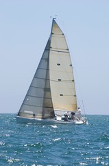 Sailboat Racing In The Blue Ocean Against Sky