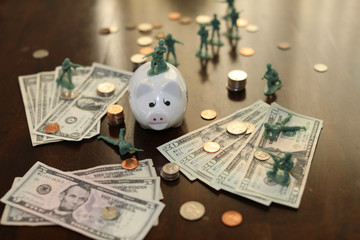 Toy soldiers guarding money and piggy bank