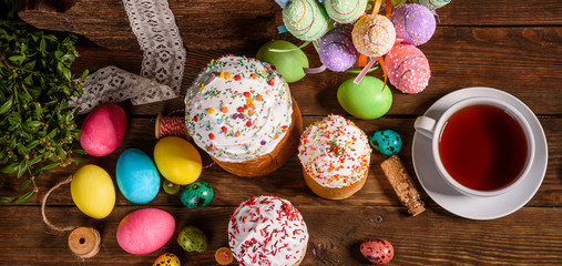 Fototapeta na wymiar Easter cake and colorful eggs on a dark background