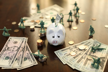 Toy soldiers guarding money and piggy bank