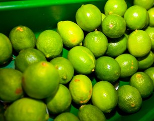 Close-up of green lemons on display in grocery store