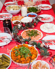 Served table with christmas decoration, red napkin, garland and candles. 