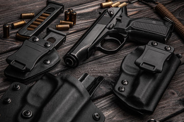 A modern black pistol and ammunition on dark metal background. Weapons for police, army, special forces.