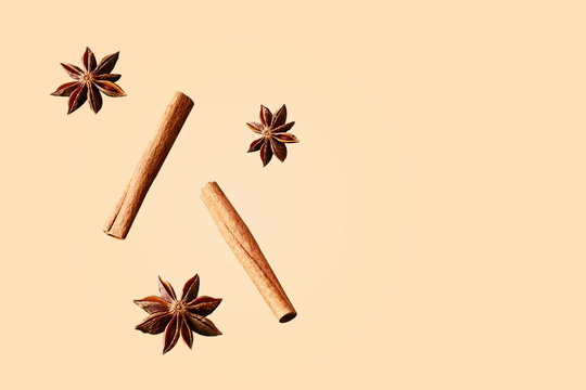 Composition of star anise and cinnamon sticks on a colored background. Star anise and cinnamon sticks flying in a air isolated