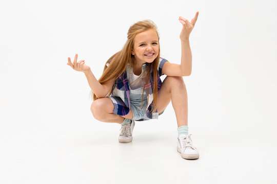 funny girl squatted and waves her hands on a white background