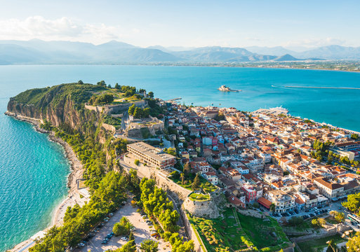 Nafplio city in Greece on green peninsula with small houses view from above at sunset