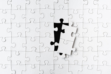 white blank jigsaw puzzle with two puzzle pieces taken out