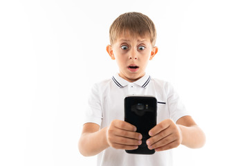 surprised boy looks at the phone on a white background