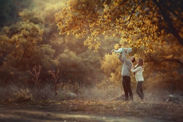 Outdoors mom dad and a small child walking on a forest trail and smile togetherness.