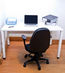 Empty office chair with laptop on desk