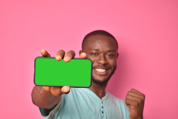 handsome excited young black man feeling excited while showing his phone screen