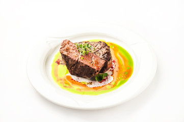 Tornedo in a restaurant close-up. Beef tenderloin steak with microgreens on a white plate and copy space.