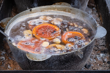 Hot spiced wine made with red wine in large copper pot Christmas food street market