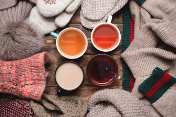 Various hot drink such as herbal tea, green tea, black tea,milk tea and warm clothes on wooden table background.