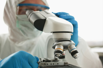 Male chemist in blue protective gloves look