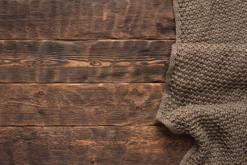 Warm brown scarf over wooden table background with copy space.
