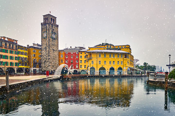 Fototapeta premium View of the beautiful Lake Garda surrounded by mountains,Riva del Garda town and Garda lake in the winter time on a snowy day,Trentino Alto Adige region