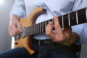 Fototapeta na wymiar Male arms playing classic shape electric guitar