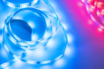 Bright neon LED strip glows blue and red. Copyspace.