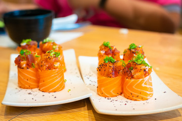 Sashimi salmon roll in white plate on. wood table in restaurant