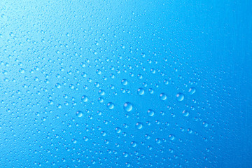 Many water drops on blue background. Texture background, macro