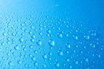 Naklejka na ściany i meble Many water drops on blue background. Texture background, macro