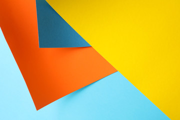 Background made of color sheets: yellow, orange and blue, close up