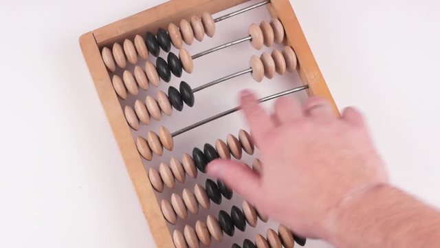 Accountant uses vintage wooden abacus on a white background. He moves wooden knuckles with his hand. Flat lay