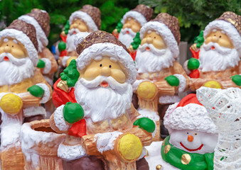 Ceramic figurines of Santa Claus with a bag of gifts and a Christmas tree.