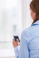 Rear View of a Woman holding a smart phone