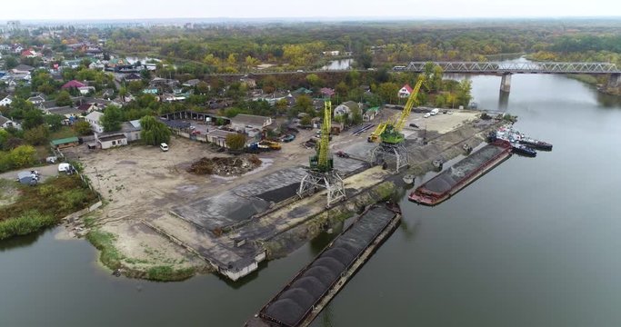 Large cranes in the port unload the barge with the material, port cranes work from the top