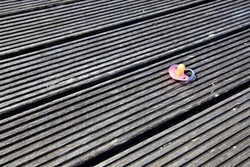 Dropped pacifier on wooden flooring
