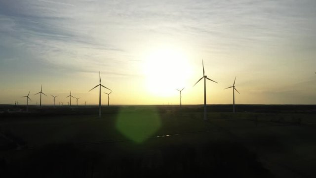 Windpark im Sonnenuntergang zur Erzeugung von regenerativer Energie für E-Mobilität - Luftaufnahme