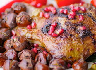 The idea for the New Year's table, baked lamb with rosemary, garlic, and hot pepper. Garnished with baked chestnutThe idea for the New Year's table, baked lamb wis and salted tomatos and pomegranates. - obrazy, fototapety, plakaty