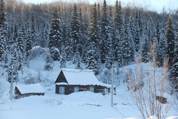 Wooden houses littered with lots of snow. Country landscape.