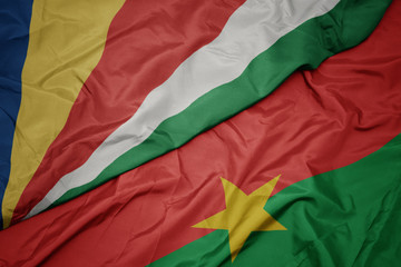 waving colorful flag of burkina faso and national flag of seychelles.