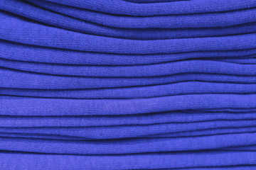 Fototapeta na wymiar clothes stacked close-up, fabric texture, bright colors, neat blue stacks