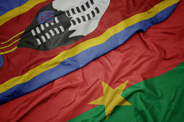 waving colorful flag of burkina faso and national flag of swaziland.