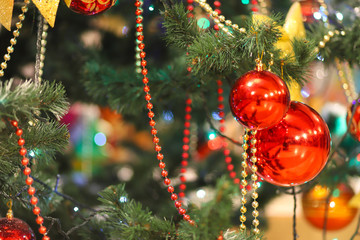 Christmas tree decorations. Decorated Christmas tree with colored red ball, golden bow, pine cones,...