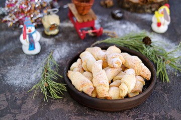 Cottage cheese cookies in the shape of bagels in a brown ceramic bowl on a dark concrete background in the New Year and Christmas style. Recipes with cottage cheese.