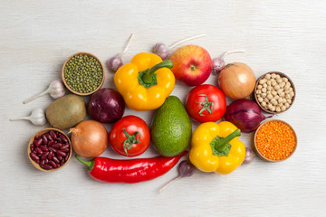 A set of vegetables for a healthy diet, yellow and red peppers, lentils and beans, walnuts, chickpeas, avocado, tomatoes, onions, garlic. .