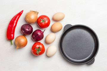 .Frying pan. A set of vegetables for a healthy diet, eggs, red peppers, tomatoes, onions, garlic.