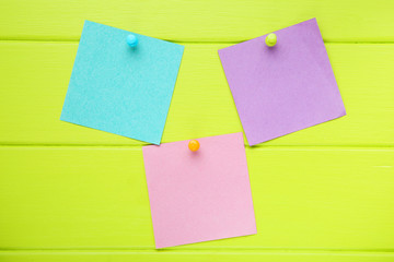 Paper sticky notes on green wooden table