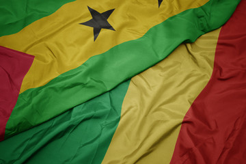 waving colorful flag of republic of the congo and national flag of sao tome and principe .