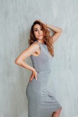 Portrait of a beautiful fashionable woman in a stylish gray dress