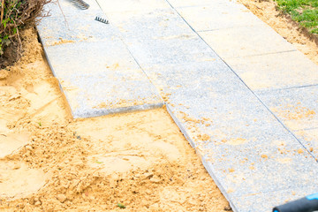 laying of gravel slabs on sand to make an alley